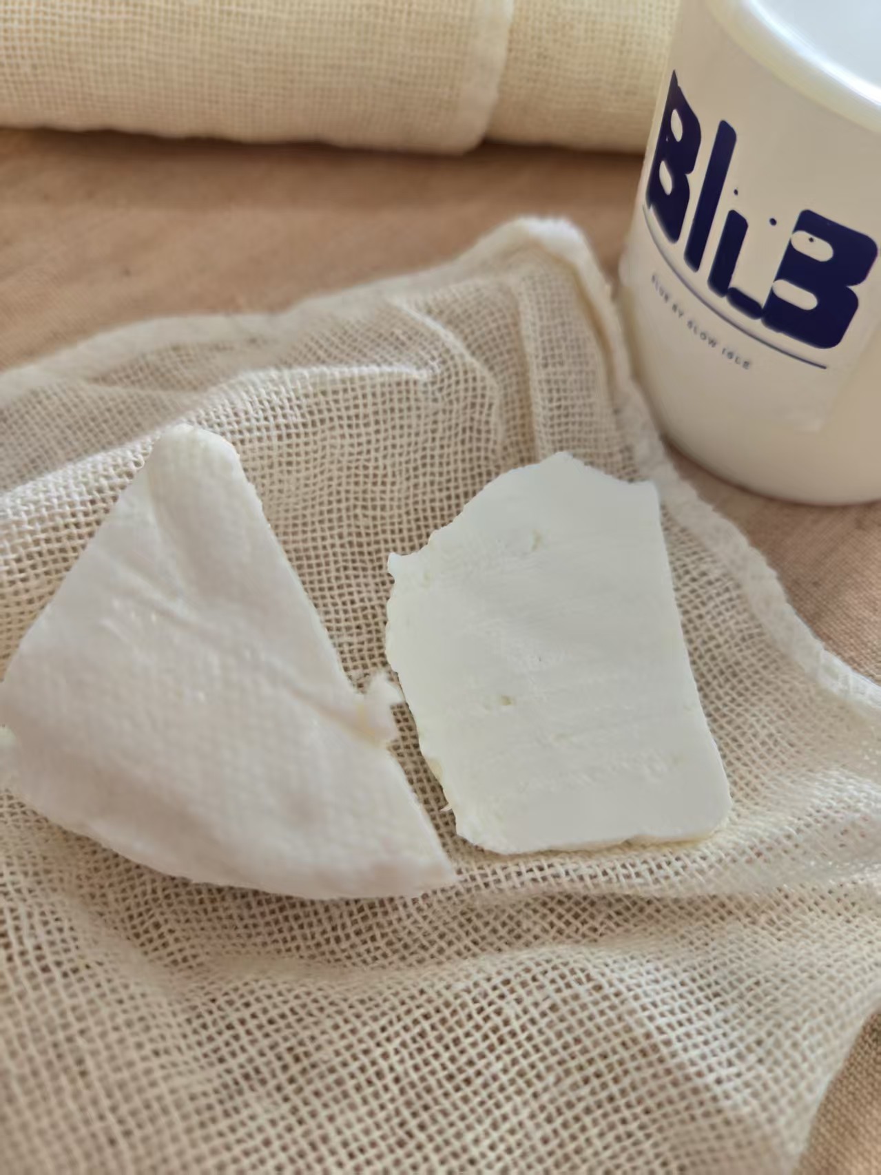 Aged kefir cheese on cloth beside a Blub cup